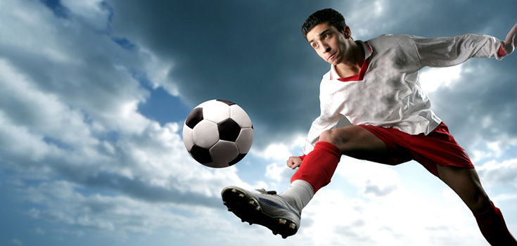 man kicking soccer ball