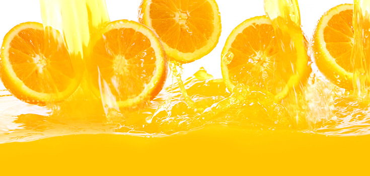 oranges splashing in orange juice