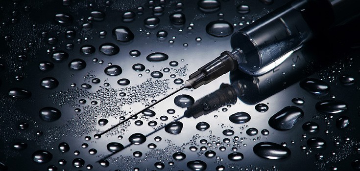 a needle surrounded by water drops