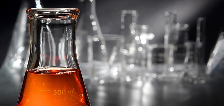 chemistry beakers with orange liquid