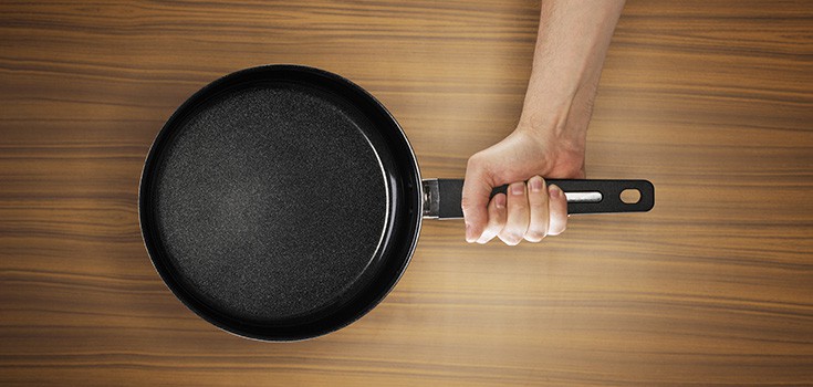 person holding a non-stick cookware pan