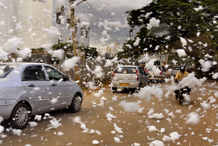 Bangalore, India was once known for its interconnected lake systems which provided a reliable source of water. As the city grew these lakes were encroached and the water became polluted day by day. The largest Bellandur Lake in Bangalore now carries huge volume of snowy froth which blocks the adjacent canals. This froth which would otherwise been a sight to behold stinks and on contact with skin causes irritation. Following a heavy rain the froth from the canal rises up and lands on the roads causing inconvenience to those travelling on two wheelers. This is a major concern with many such lakes in Bangalore which are getting polluted with harmful chemicals like nitrates, potassium, sulphates, etc. Although the residents have raised their concern by informing the local media for cleaning the lake, till date the Government has not taken adequate measures. The lake now emits intoxicating smell and blew froth all around whenever there is wind. Despite all such issues new residential complexes are still coming up. The affected area would be around 200 meters and if it too windy the froth flies even further entering the neighbouring houses. The people residing nearby the lake are suffering from several health issues.